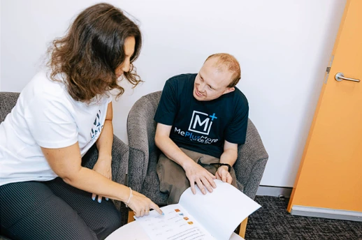 Participant reviewing learning materials with Me Plus More support worker